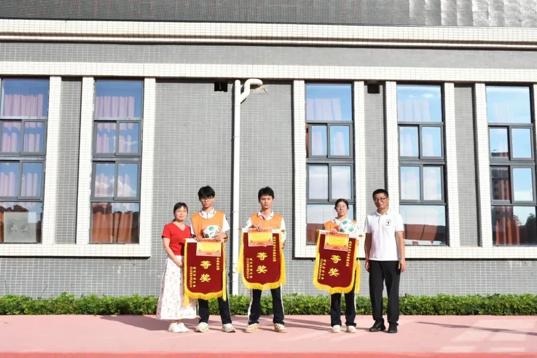 跑操比赛获奖班级展示他们的奖状和锦旗