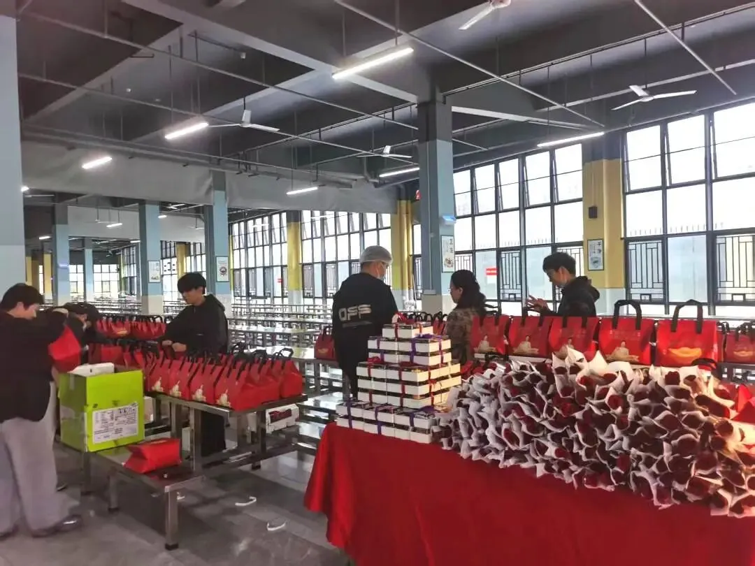 女教职工收到鲜花和蛋糕，脸上洋溢着幸福的笑容