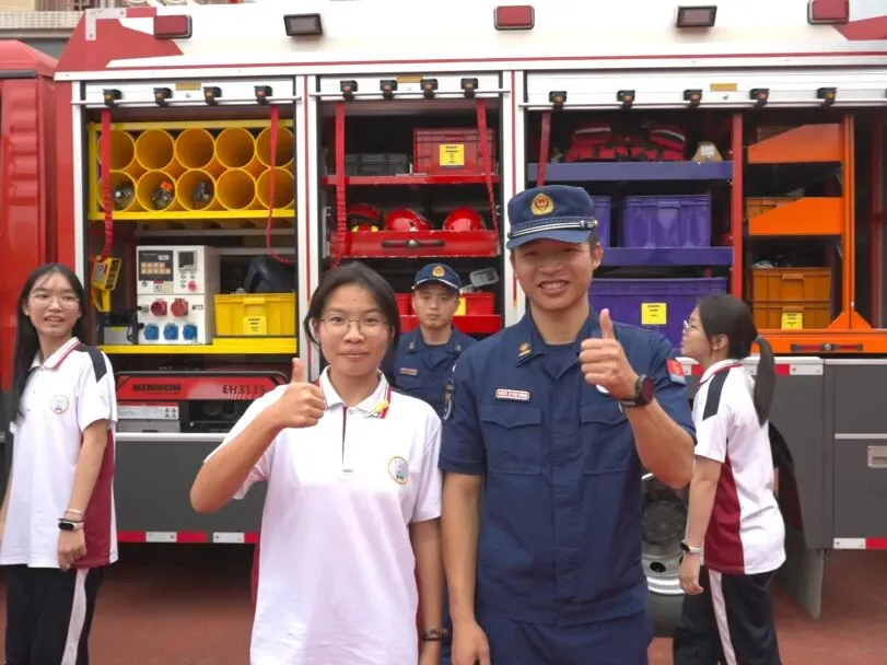 学生们在消防员指导下进行灭火演练