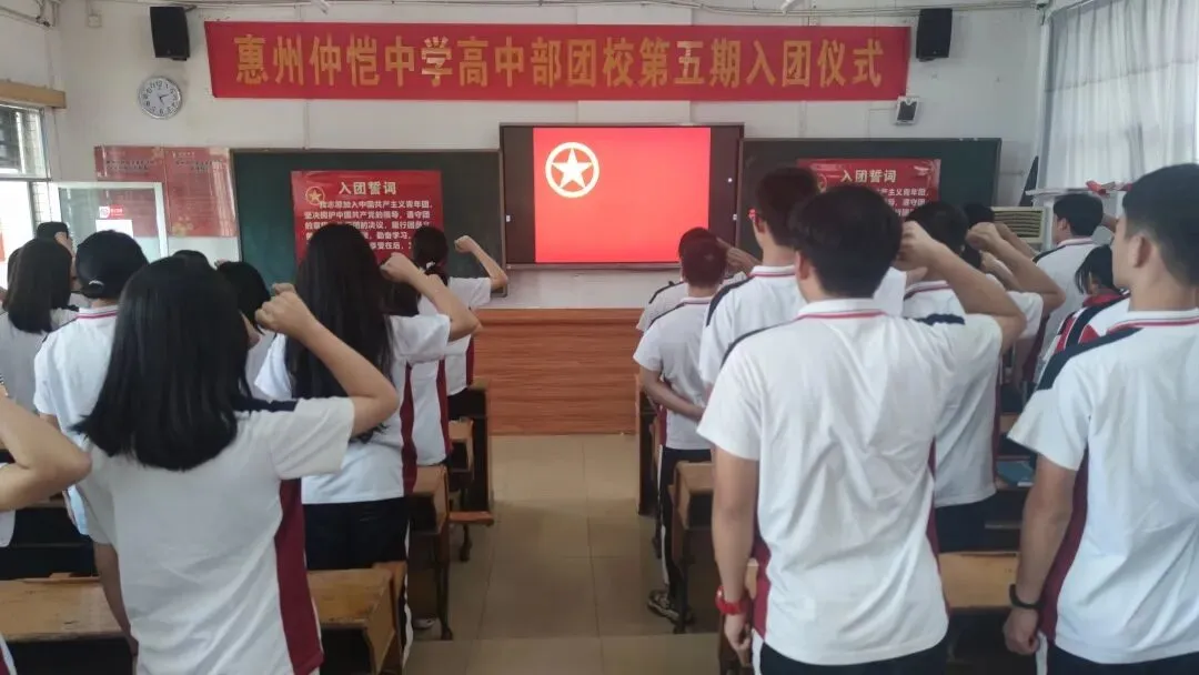 新团员们在团旗下庄严宣誓,举起右手
