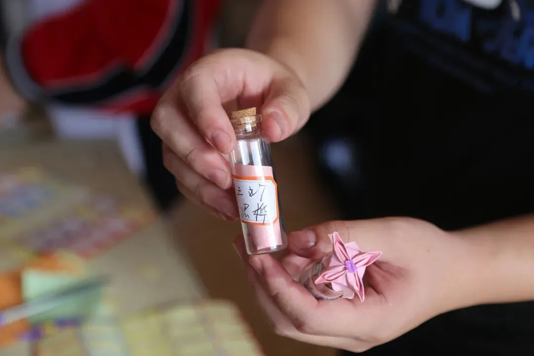 学生们将写好的祝福卡片放入漂流瓶中
