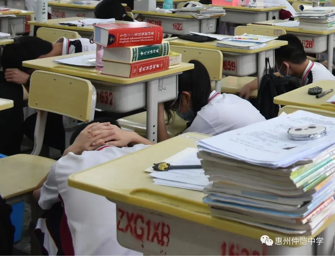 学生们在老师的指挥下,捂住口鼻,低姿快速撤离教室