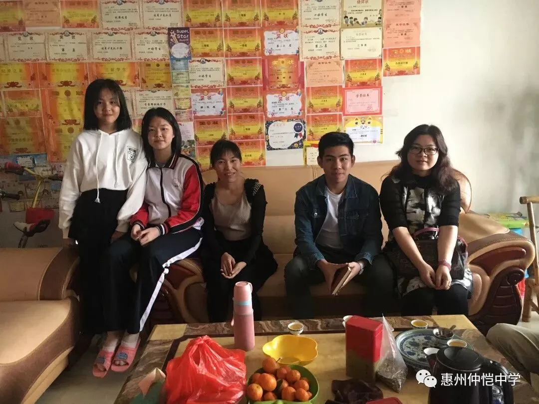 家访教师在学生家中与家长合影留念