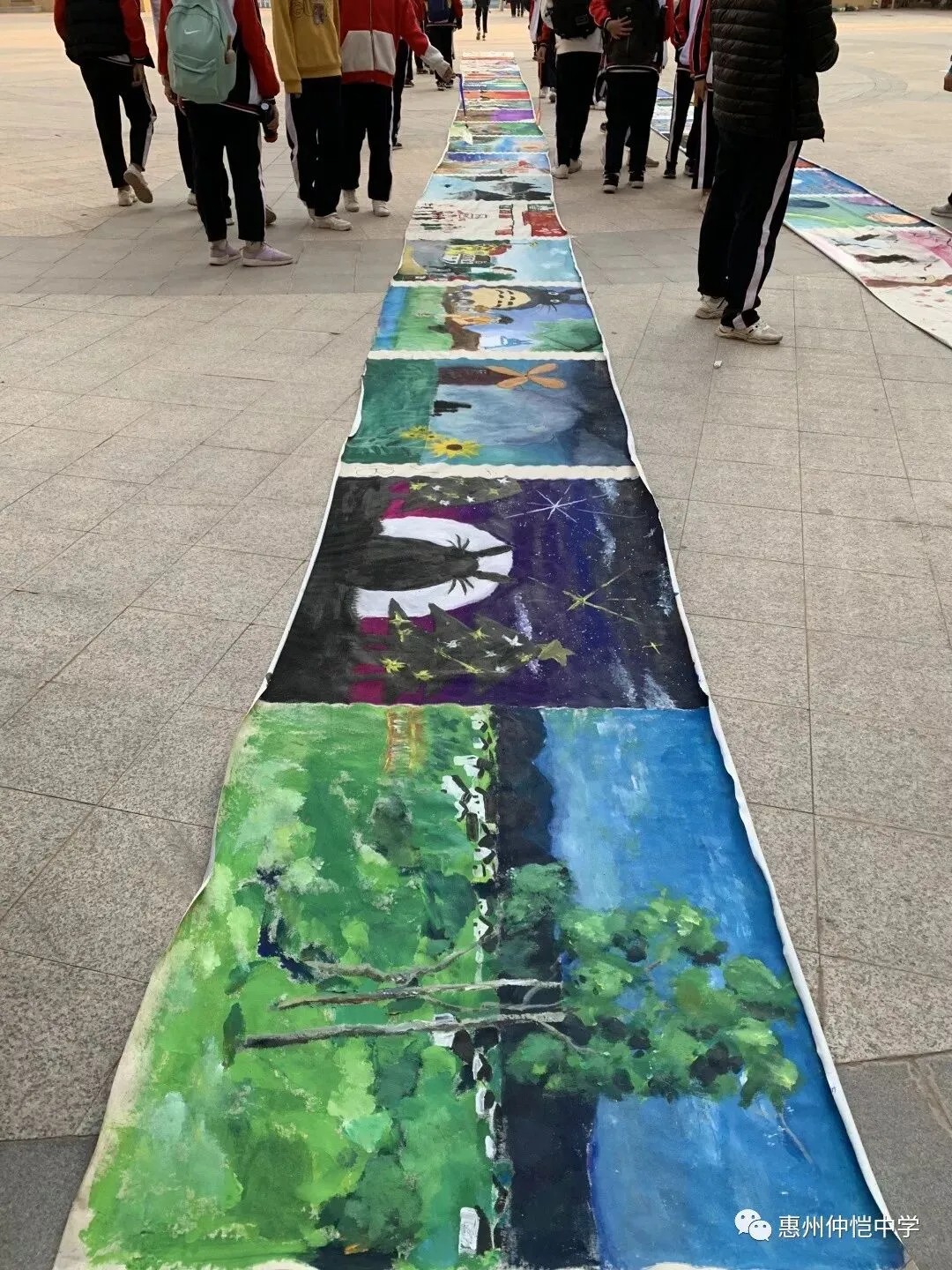 学生们在百米长卷上认真绘画,展现创作热情
