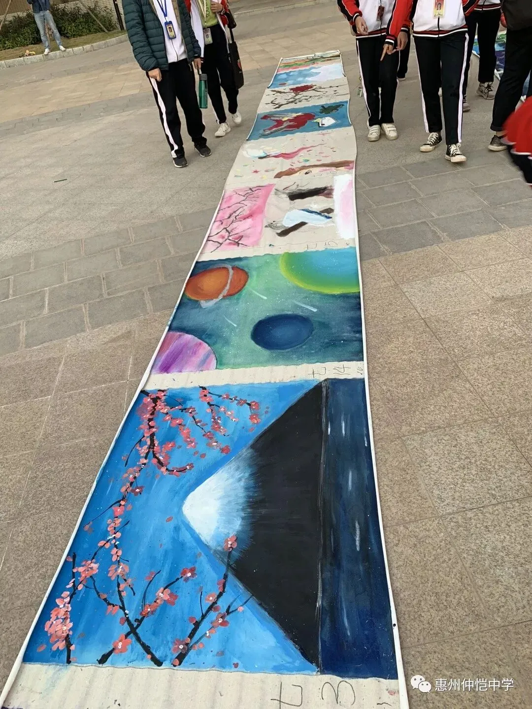 美术老师和学生们在百米长卷上共同创作
